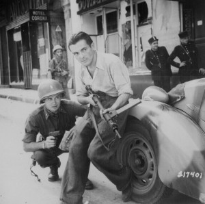 Pictured here are an American officer and a French partisan crouching ...