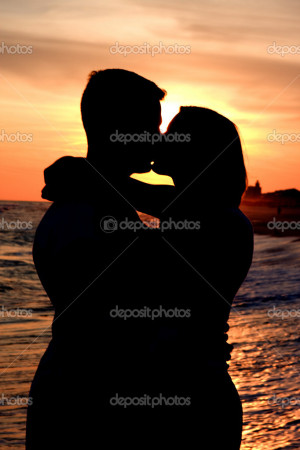 Man and Woman Kiss at Sunset - Stock Image