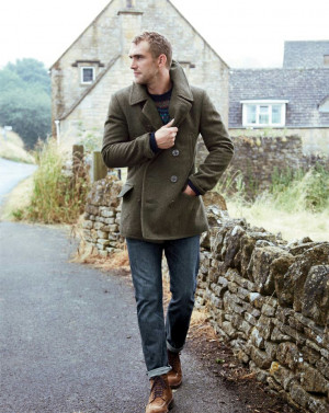 olive pea coat and blue jeans and brown boots and navy crew neck