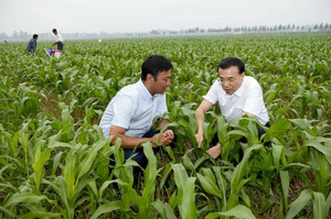 Premier Li Keqiang talks with a farmer during a visit to a family-run ...