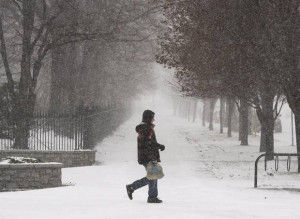 pedestrian walks through the snow at the start of a winter storm in ...