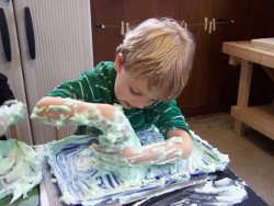 Kindergarten boy delights in a mound of green foam on St. Patrick's ...