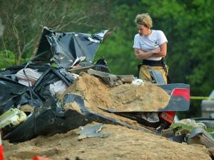 Cary EMS worker looks at the mangled wreck of a Honda Civic in which ...