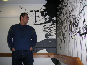 John Biddle withthe new mural at SoundHouse Otara Music ArtCentre