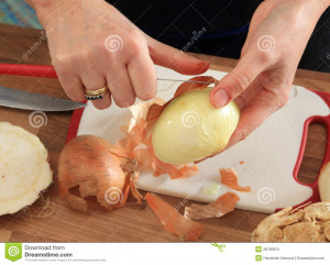An Onion is peeled in order to cut it to small pieces afterwards. In ...