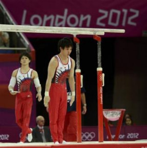 Kohei Uchimura of Japan (L) walks past teammate Yusuke Tanaka during ...