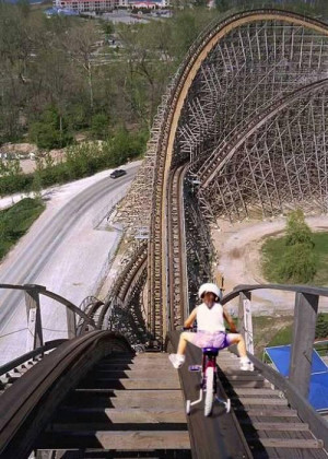 little girl takes bike on roller coaster