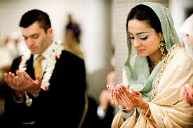 Muslim couple saying a dua’ (prayer) at their wedding.