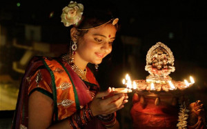 girl lights an earthen lamp to celebrate Diwali, the Hindu festival ...
