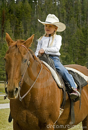 Little cowgirl out for a ride on her bay horse - focus on the girl.