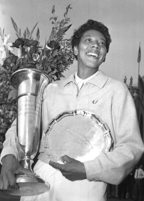 Althea Gibson smiles as she holds her trophies she won by capturing ...