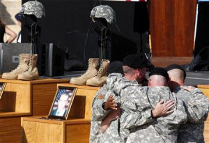 Army soldiers hug in front of fallen soldier memorials for the ...