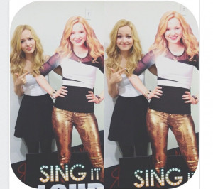 Dove standing next to a full size cut-out of her from 