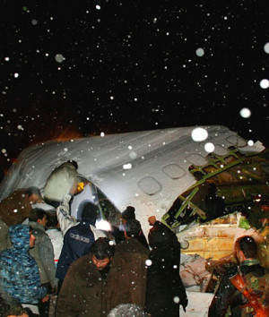 Firefighters and Red Crescent rescuers work near the wreckage of a ...