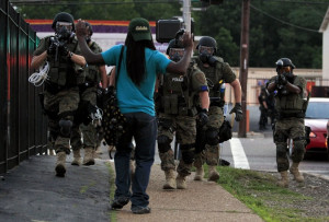 Police in riot gear walk toward a man in Ferguson, Mo. on Aug. 11 ...