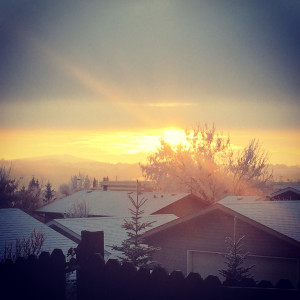 Snow-covered roofs and houses in the foreground, with a Chinook arch ...