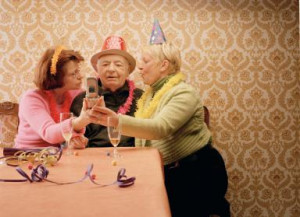 ... man mobile phone, wearing party hats - Sean Ives/ Stone/ Getty Images