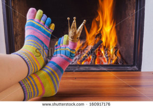 relaxing at fireplace in colorful funny toe socks - stock photo