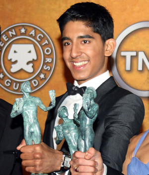 Dev Patel poses with his award for Outstanding Cast