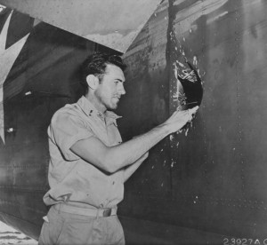 Louis Zamperini inspects a damaged plane as a member of the United ...