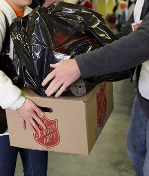 Salvation Army volunteer helps a woman with a box a food.