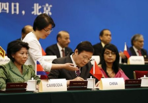 China's Finance Minister Lou Jiwei signs a document, with the guests ...