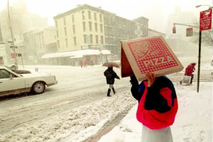 Pizza delivery man shielding himself from blizzard, New York
