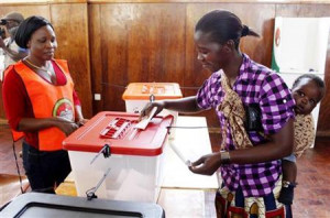 mother casts her vote with a baby on her back during the ...