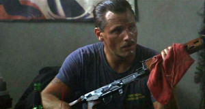 Master Chief Urgayle (Viggo Mortensen) cleaning his weapon while ...