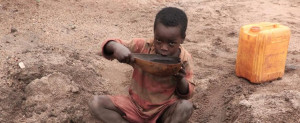 young boy drinking water from an unsafe source
