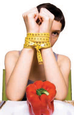 person with their wrist tied up with a red pepper in front of them.