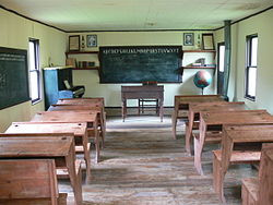 Well equipped one-room school (with desks, blackboard, books, globe ...