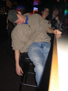 Drunk guy asleep in a bar after drinking too much alcohol