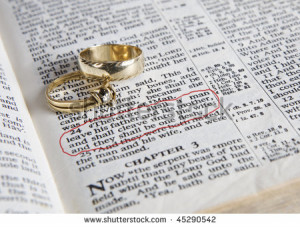 Wedding rings place on an open Bible to a verse in the book of Genesis ...