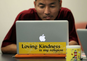his laptop computer, Tibetan monk Ngawang Norbu works with other monks ...