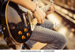 guitar player playing song outdoor - stock photo