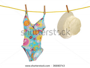 child's bathing suit and beach hat on clothes line - stock photo