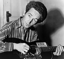 Woody Guthrie with guitar labeled 