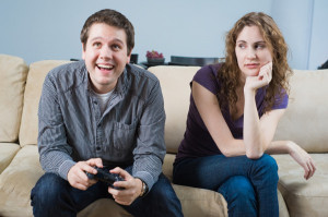 Unhappy girlfriend watches boyfriend play video games