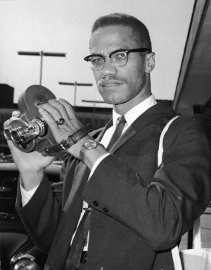 Malcolm X holds a movie camera during a visit to London in 1964.