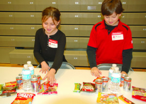Sarah Isom-Wright (left) and Myles Daugherty arrange snacks for people ...