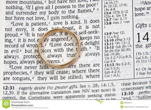 wedding ring on a bible open to marriage scripture.