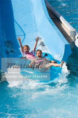 ... -Girls-sliding-down-water-slide-on-innertube-in-water-park---.jpg
