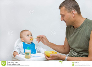 Man Feeding Baby With Spoon...