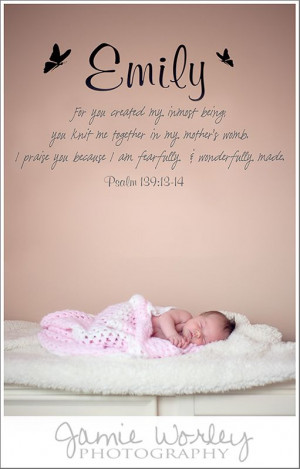 newborn baby with Bible verse on nursery wall