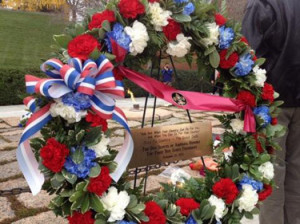 The wreath includes Kennedy's famous quote 