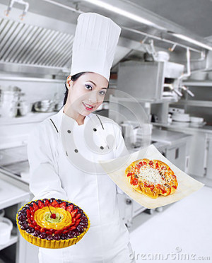 Beautiful chef is serving fruit cake and pizza.