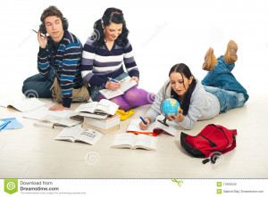 Three students sitting on floor and doing their homework together.