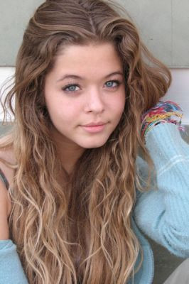 Appearance: She is 15, has brown curly hair and green eyes.