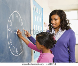 Teacher and female student at the blackboard with clock drawing on it ...